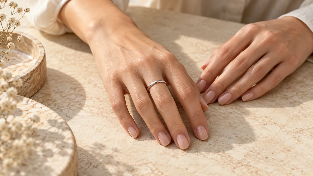 Conceptual editorial close-up of an adult hand wearing a simple generic ring; no injury or ARVENIER product is shown.