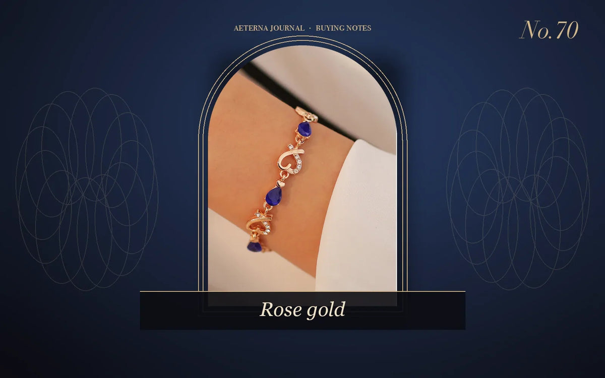 Rose-gold heart link bracelet with blue stones worn on the wrist